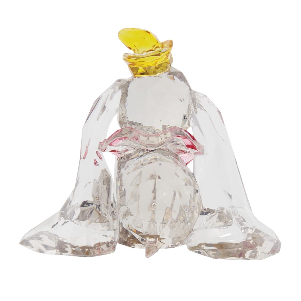 Dumbo Facets Figurine  This "gem cut" acrylic sculpture reflects the ninth wonder of the universe. The world's only flying elephant. Dumbo is already for his circus debut with his yellow hat and pink collar. Presented in a branded window gift box.