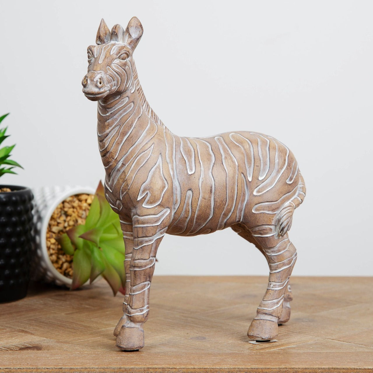 Embossed Zebra Figurine 23cm  Bring some exotic vibes to your home with this carved sandstone effect resin zebra ornament. From the Global Artisan collection by HESTIA® - bring a touch of the exotic to your home.