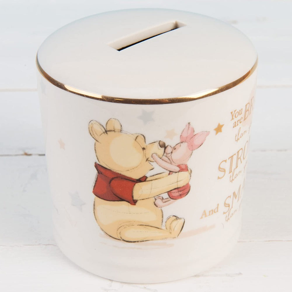 Disney Magical Beginnings Ceramic Money Box Bank - Winnie the Pooh  Evoke the magic of Disney with this Winnie The Pooh money bank.  As part of our Disney Magical Beginnings range, this beautiful money bank features an original sketch of Winnie the Pooh and Piglet, with the sentiment 'You are braver than you believe, stronger than you seem and smarter than you think' in gold foil lettering.