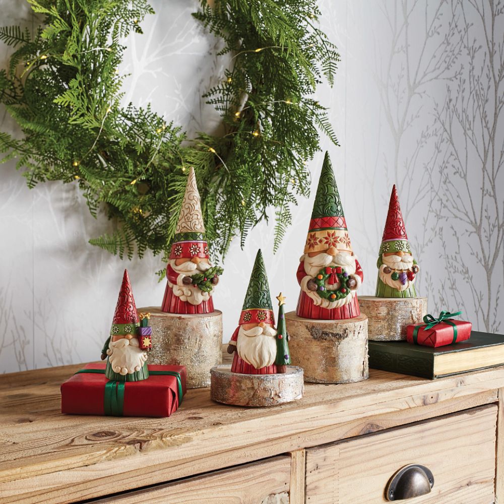 Jim Shore Heartwood Creek Christmas Gnome Holding Holly  "Sprig of Christmas Spirit" There's no place like gnome for Christmas. Celebrate the season with this incredibly crafted holiday gnome by Jim Shore. Patterned in delicate engravings and flowers, this gnome holds a bushel of holly with a moustache hidden smile. 