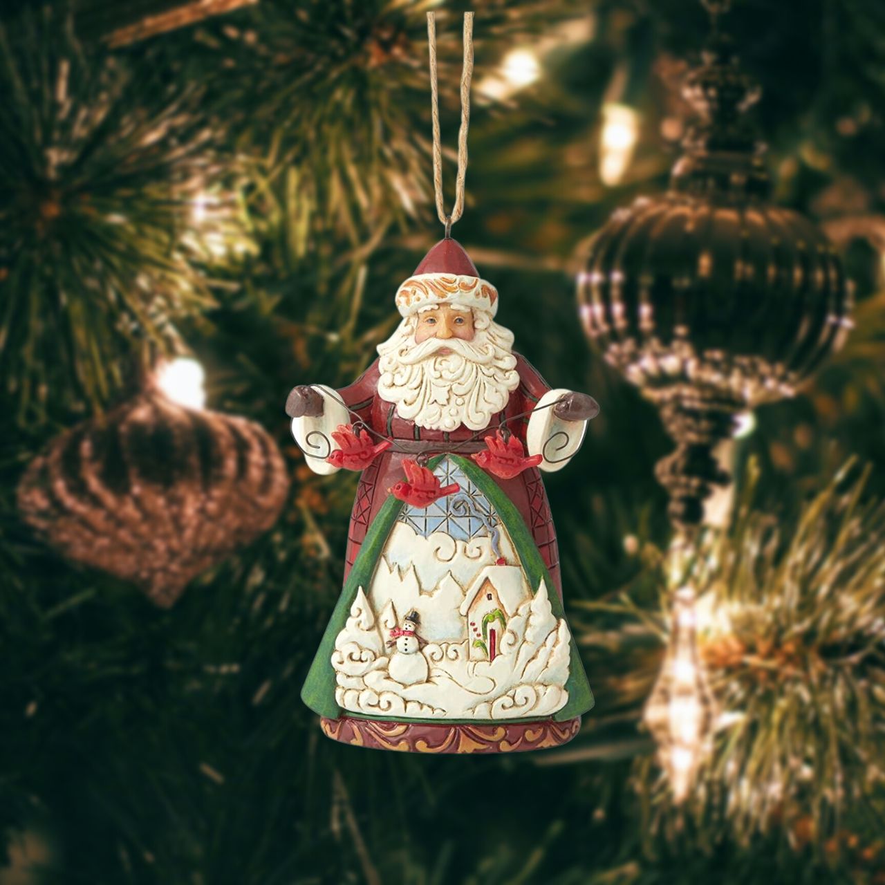 Jim Shore Heartwood Creek Santa with Cardinals Hanging Ornament  Designed by award-winning artist and sculptor Jim Shore for Heartwood Creek. Ornament hangs by jute rope and features a handcrafted look. Item is packed in a branded craft box.