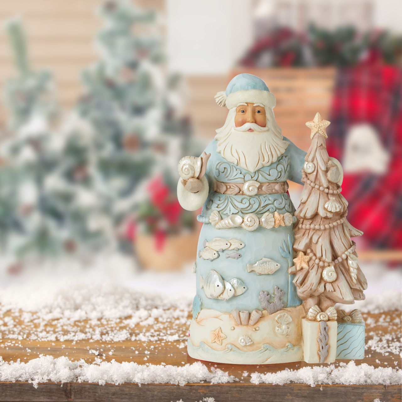 Santa with Starfish Tree Figurine  The joy of Christmas festivities meets the relaxing calm of the sea in this Costal Collection for Heartwood Creek by Jim Shore. This stunning Santa in blue adorned with shells and coral is truly delightful.