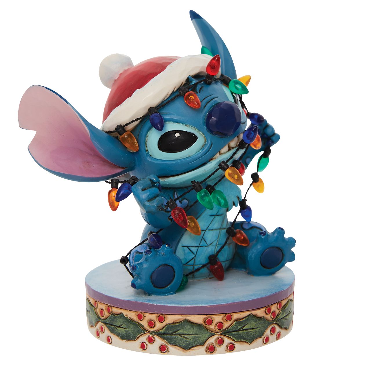 Stitch Wrapped in Lights Figurine  Disney comes home for the holidays with this festive figurine by Jim Shore. Attempting to help his Ohana decorate, Stitch gets caught up in Christmas preparations. Tangled in lights, the little alien tries to escape while wearing a Santa hat.