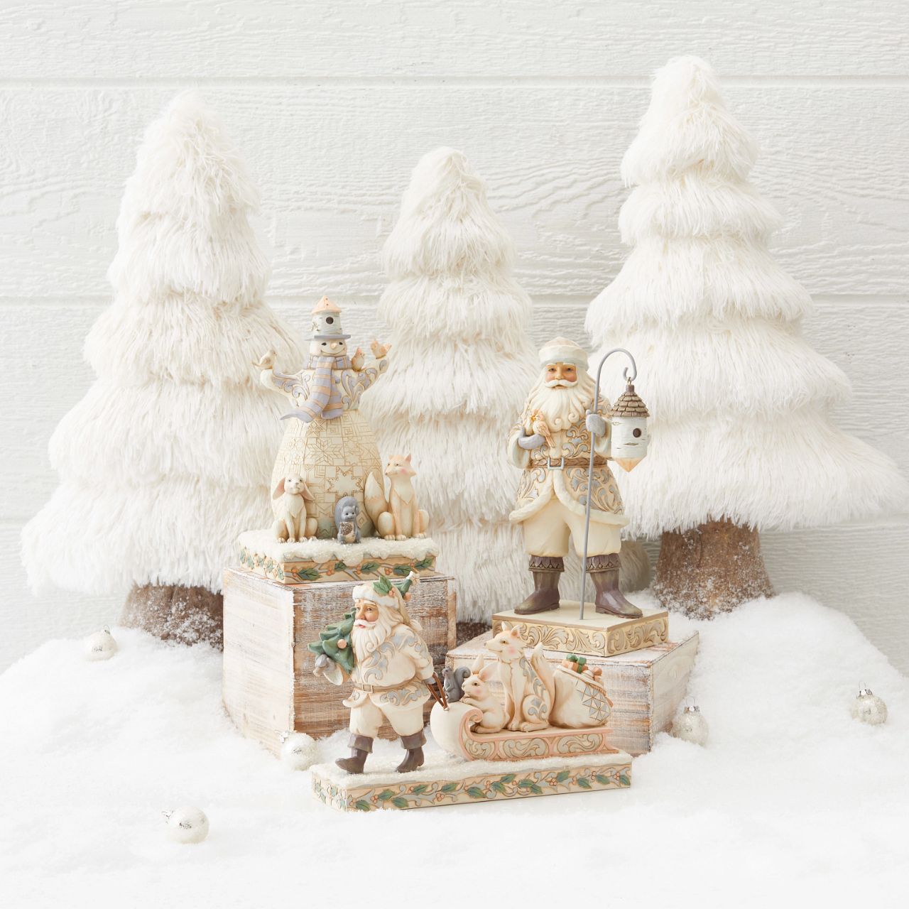 Jim Shore White Woodland Santa Pulling Sled Figurine  "A Wandering We Go" Santa is getting ready for Christmas with his furry friends. This piece features Santa dressed in the iconic, muted colours of White Woodland, whilst pulling a sled of forest animals and gifts.