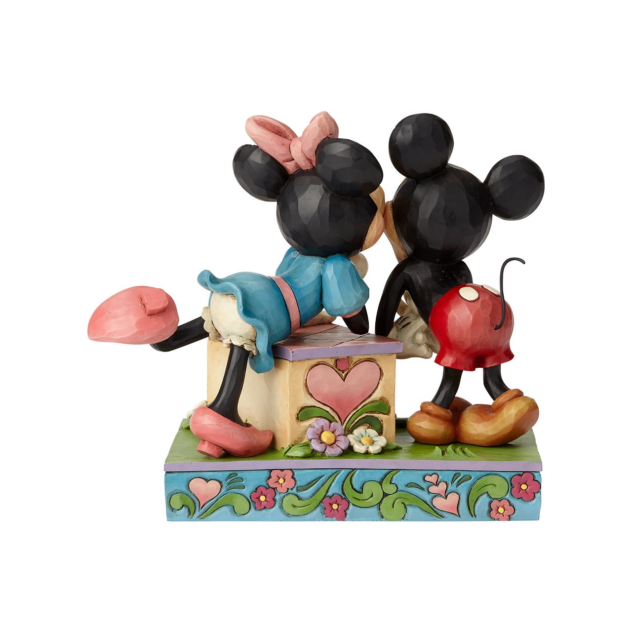 Jim Shore Kissing Booth Mickey Mouse and Minnie Mouse  Minnie leans over a kissing booth to plant a smooch on one very smitten Mickey in this cheeky scene by Jim Shore. Handcrafted in his unique folk art style, the cast stone design features whimsical rosemaling and quilt patterns.