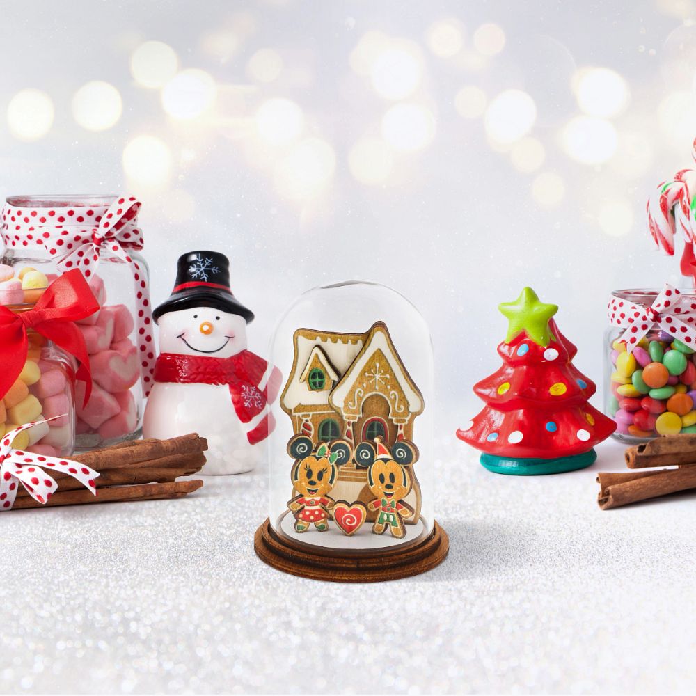 Home for Christmas Mickey and Minnie with Gingerbread House Kloche  Mickey and Minnie Mouse share their love for Christmas time in front of a cute gingerbread house and create a wonderful magical, family moment in this delightful wooden figurine. This gingerbread inspired decorative Kloche will make a stunning display in your home.