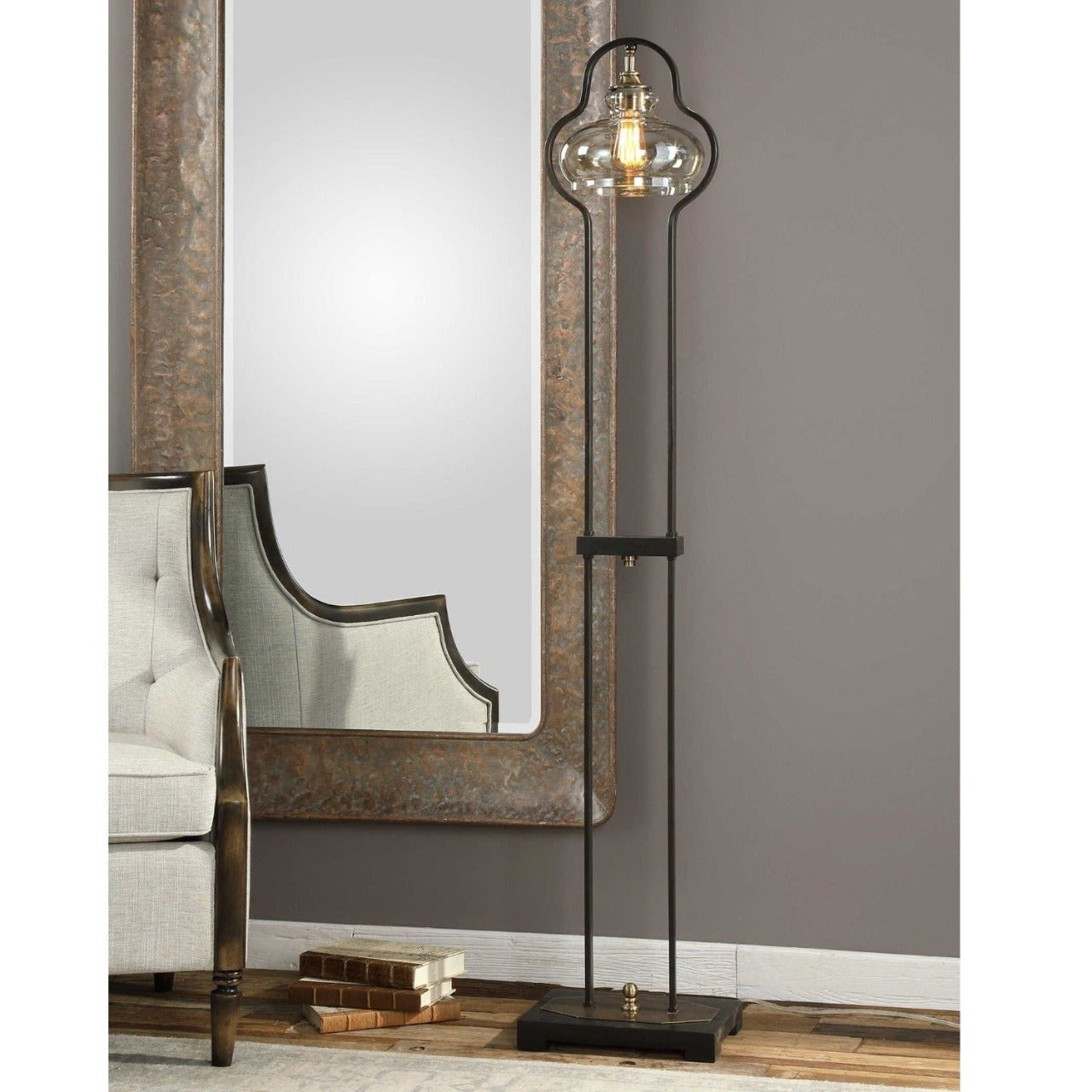 Mindy Brownes Cotulla Lamp  Curvaceous forged iron finished in an aged black, following the contour of the light amber glass shade, accented with brushed, antiqued brass plated details. 60 watt, BT-58 antique style bulb included.