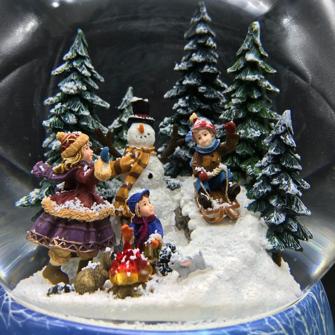 Music Box World Snow Globe Snowman - Large  Snowman snow globe plays the melody “Leise Rieselt der Schnee”. The snow swirls automatically and the camp fire lights up.  Melody: Leise Rieselt der Schnee