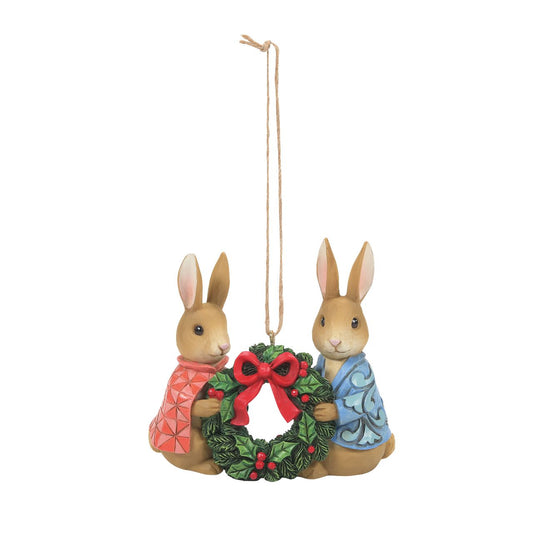 Jim Shore Peter Rabbit with Flopsy holding wreath Hanging Ornament  The holidays are about spending time with those we love most. This sweet ornament by Jim Shore features cherished Beatrix Potter characters, Peter Rabbit and Flopsy, holding a festive wreath. In their classic garb, the pair celebrate togetherness.