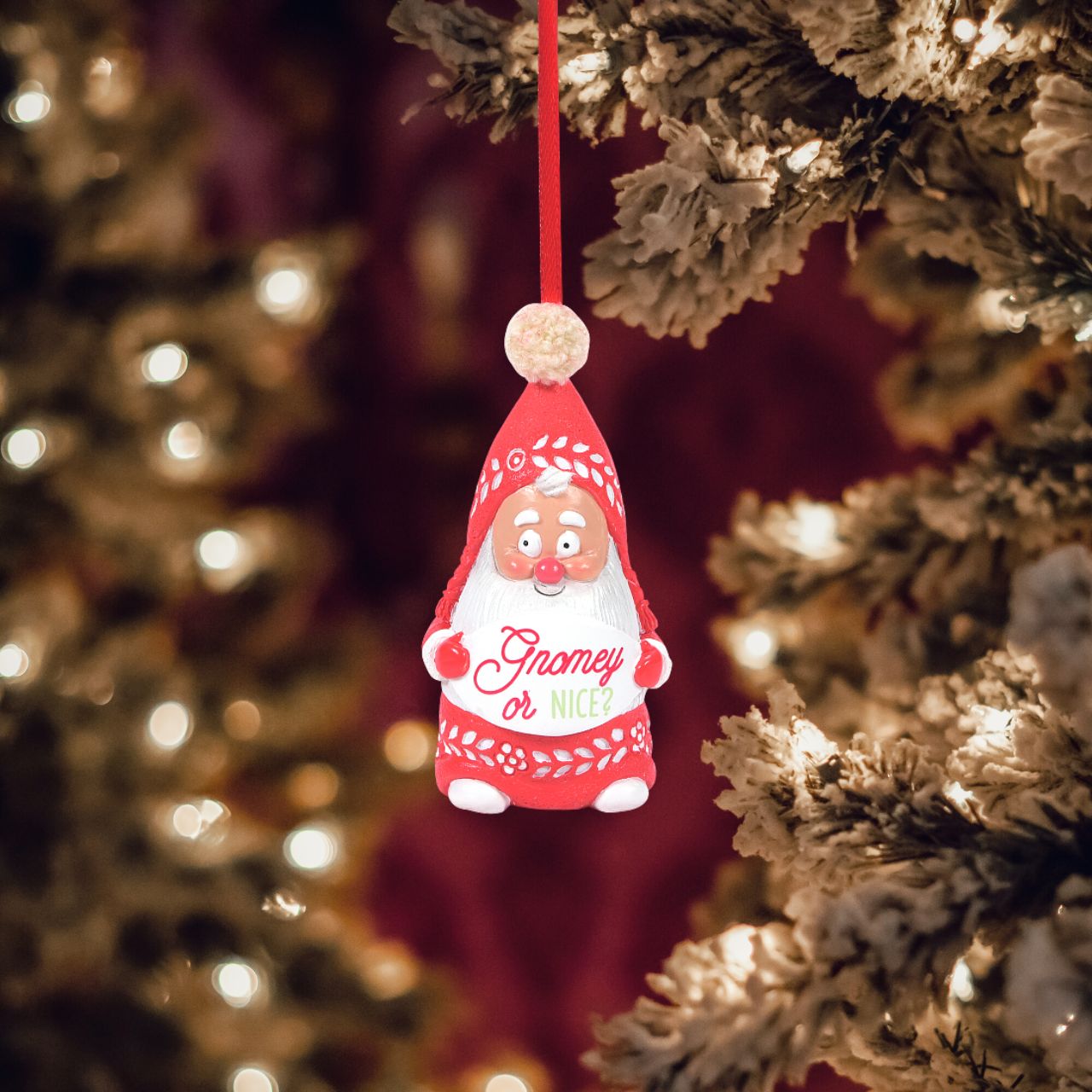 Department 56 Snowpinions Snow Gnome Gnomey or Nice Hanging Ornament  Are you on Santa's nice list this year? This Snow Gnome wants to know. He is hand crafted from high quality cast stone, hand painted by our skilled artists and then topped with a real pom pom. Hanging from a festive red ribbon, he is the perfect accessory to any Christmas Tree.