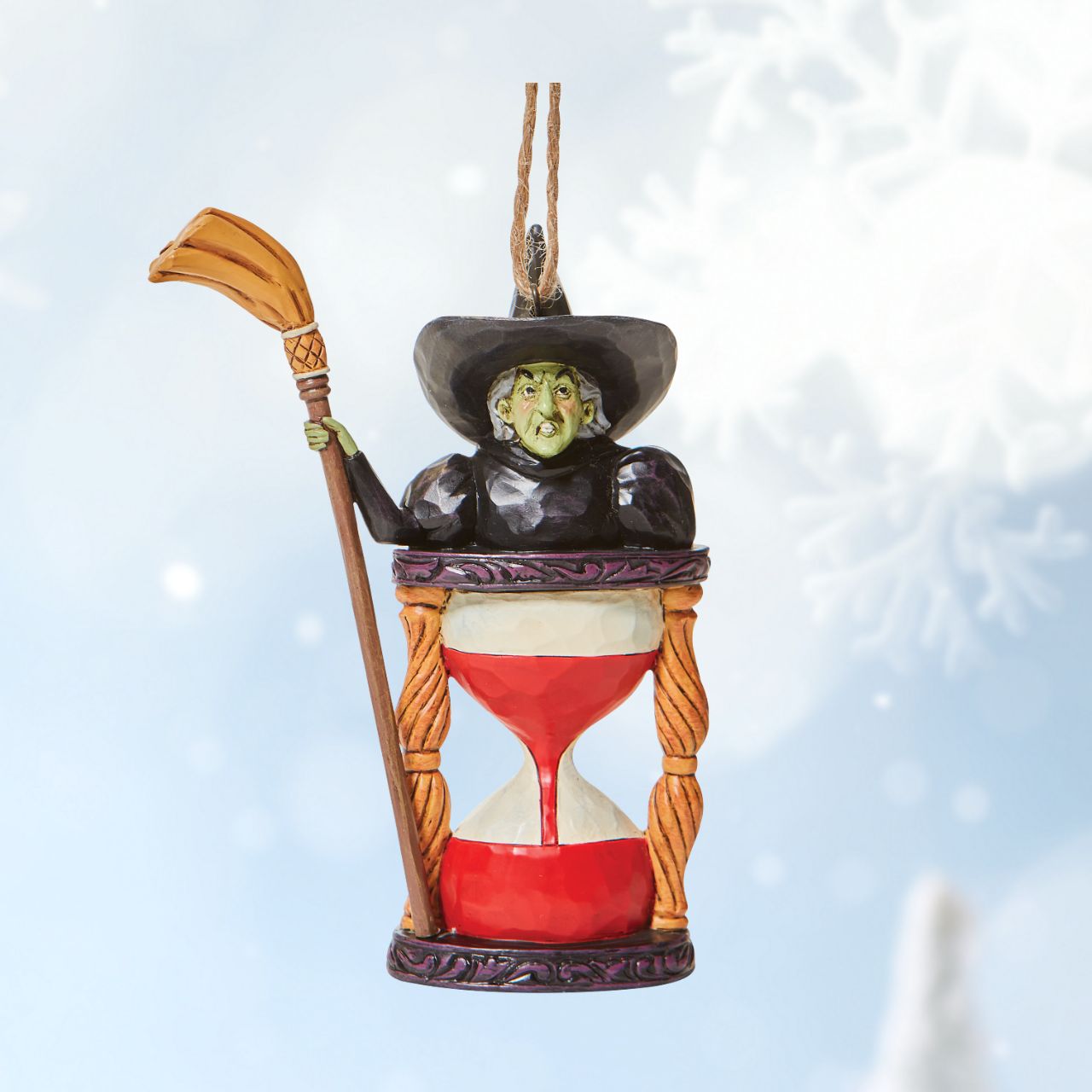 Jim Shore Wicked Witch with Hourglass Hanging Ornament  Someone looks unhappy in this hourglass ornament. As the sands of time fall, the Wicked Witch frowns knowing it's only a matter of time until good wins the day. Place this green-faced miscreant into your tree and watch her moments before melting.